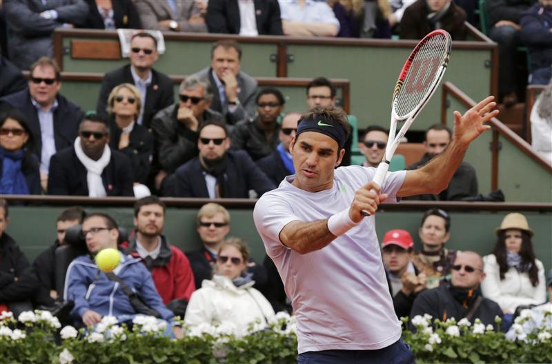 Federer of Switzerland hits a return to Carreno-Busta of Spain during their men's singles match at the French Open tennis tournament in Paris