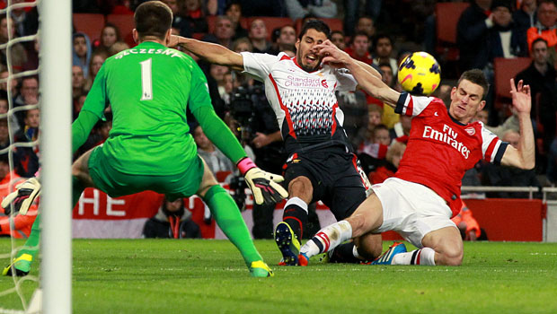 Liverpool Luis Suarez and Arsenal Laurent Koscielny in action